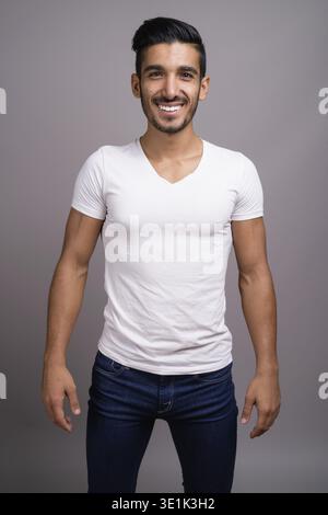 Studio shot der jungen schönen persischen Mann gegen grauer Hintergrund Stockfoto