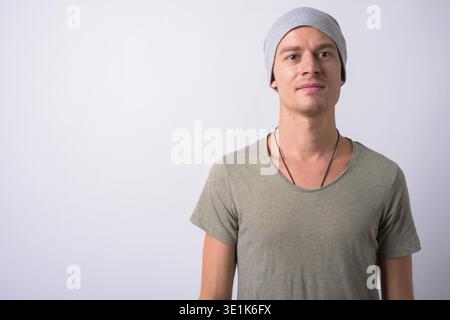 Studio-Aufnahme eines gutaussehenden Mannes, der Militäruniform vor weißem Hintergrund trägt Stockfoto