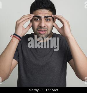 Studio-Aufnahme eines jungen gutaussehenden bärtigen Indianers vor weißem Hintergrund Stockfoto