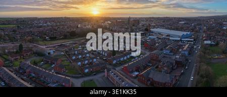 Luftbild mit Blick nach Nordwesten über Bolton, mit traditionellen Wohnstraßen und industriellem Erbe vor einem dramatischen Sonnenuntergang in Lancashire. Stockfoto