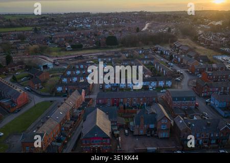 Luftbild mit Blick nach Nordwesten über Bolton, mit traditionellen Wohnstraßen und industriellem Erbe vor einem dramatischen Sonnenuntergang in Lancashire. Stockfoto