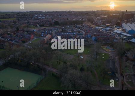 Luftbild mit Blick nach Nordwesten über Bolton, mit traditionellen Wohnstraßen und industriellem Erbe vor einem dramatischen Sonnenuntergang in Lancashire. Stockfoto