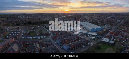 Luftbild mit Blick nach Nordwesten über Bolton, mit traditionellen Wohnstraßen und industriellem Erbe vor einem dramatischen Sonnenuntergang in Lancashire. Stockfoto
