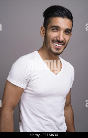 Studio shot der jungen schönen persischen Mann gegen grauer Hintergrund Stockfoto