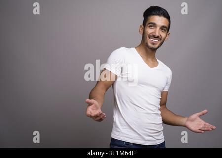 Studio shot der jungen schönen persischen Mann gegen grauer Hintergrund Stockfoto
