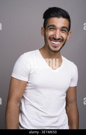 Studio shot der jungen schönen persischen Mann gegen grauer Hintergrund Stockfoto