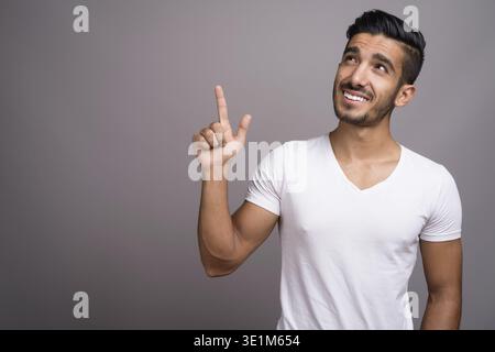 Studio shot der jungen schönen persischen Mann gegen grauer Hintergrund Stockfoto