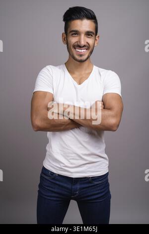 Studio shot der jungen schönen persischen Mann gegen grauer Hintergrund Stockfoto