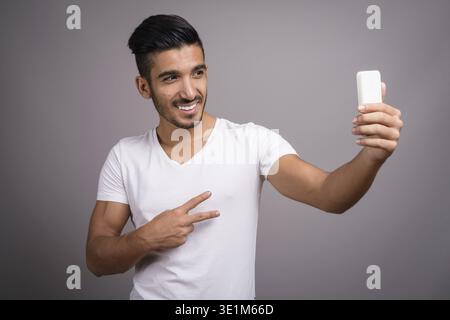 Studio shot der jungen schönen persischen Mann gegen grauer Hintergrund Stockfoto