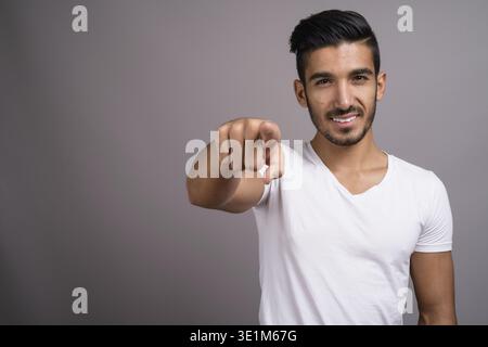 Studio shot der jungen schönen persischen Mann gegen grauer Hintergrund Stockfoto