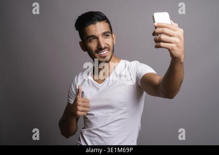 Studio shot der jungen schönen persischen Mann gegen grauer Hintergrund Stockfoto