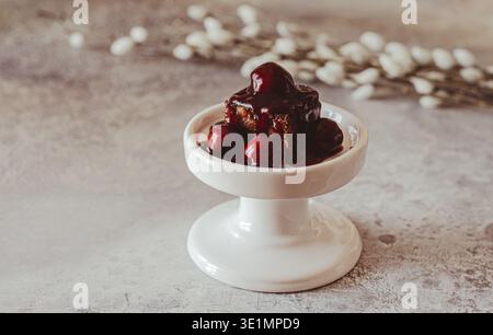 Hausgemachter Gluten- und zuckerfreier Brownie mit Kirschen auf weißem Mini-Kuchen-Teller Stockfoto