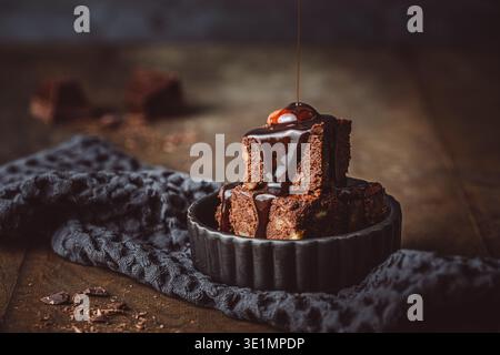 Hausgemachter Gluten- und zuckerfreier Brownie mit Schokoladensoße auf rustikalem dunklen Hintergrund, Kopierraum Stockfoto