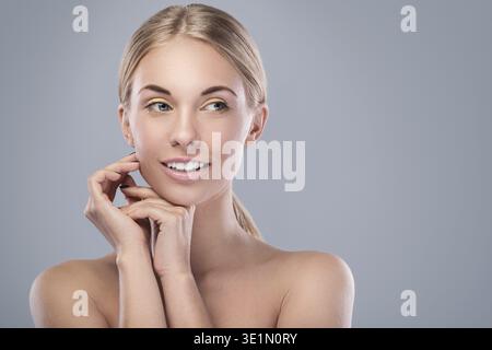 Schöne blonde Frau mit hellen Make-up im Studio Stockfoto