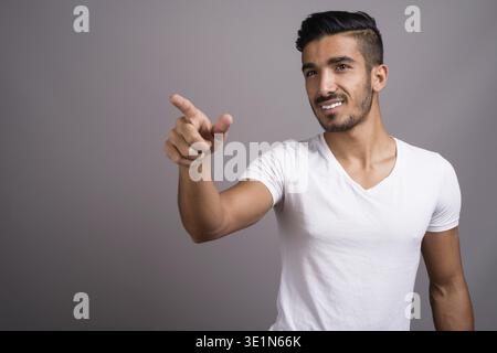Studio shot der jungen schönen persischen Mann gegen grauer Hintergrund Stockfoto