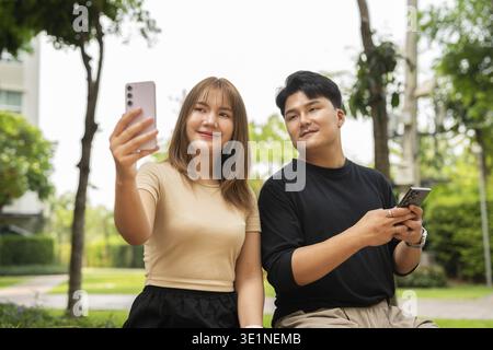 Junge glückliche asiatische Paare draußen im Park Stockfoto