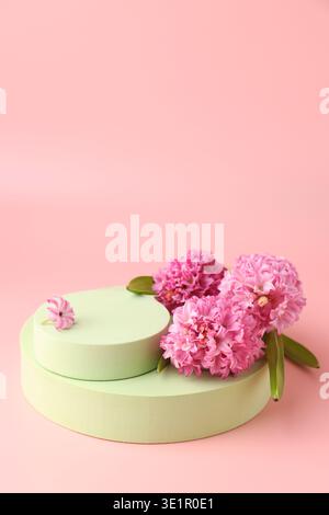 Leere Podeste und Frühlingsblumen auf rosa Hintergrund. Modell für Design Stockfoto