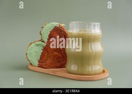 Trinken Sie Getränk Kaffee Cappuccino Latte köstliches frisches Croissant mit Matcha Green Tea Flavor Ganache. Creation einzigartige Bäckerei in Herzform. Blätterteig Urlaub Liebe Geschenk Geschenk Idee Valentinstag. Kopierbereich Stockfoto