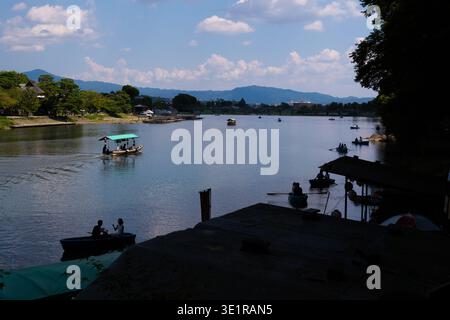 Panoramablick auf Ruderboote und traditionelle Vergnügungsboote auf dem Fluss Katsura mit Bergen in der Ferne. Arashiyama, Kyoto, Japan. Stockfoto