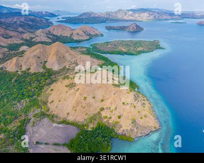 Bei einem atemberaubenden Blick aus der Luft auf den Komodo-Nationalpark in Indonesien zeigt sich türkisfarbenes Wasser mit üppigen Inseln in einem lebendigen Wandteppich der Natur Stockfoto