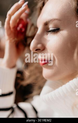 Frauenporträt Nahaufnahme einer jungen Frau mit geschlossenen Augen im Sonnenlicht, was eine ruhige und ruhige Stimmung widerspiegelt Stockfoto