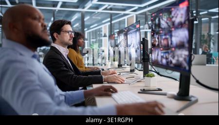 Im Sicherheitsraum untersucht Eine junge Frau Videomaterial auf mehreren Monitoren Stockfoto