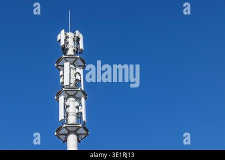 Telekommunikations-Tower-Zellstandort mit mehreren Mobilnetzantennen und Sendern für 5G und 4G in Zukunft 6G-Signalabdeckung gegen Clear Stockfoto