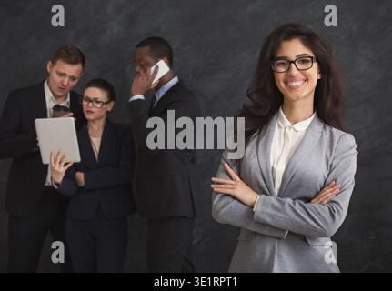 Glückliche Geschäftsfrau Porträt vor dem Arbeitsteam Stockfoto