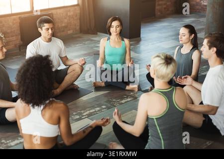 Verschiedene Gruppen meditieren im Yoga-Unterricht Stockfoto