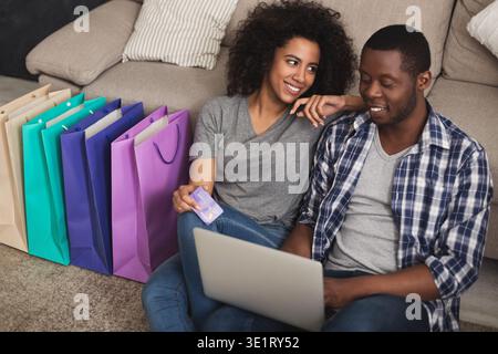 Ein junges schwarzes Paar, das online einkaufen will Stockfoto