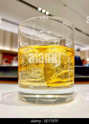 Eine Nahaufnahme eines Steinglases mit Eis und Whiskey auf einem Festsaal-Tisch. Stockfoto