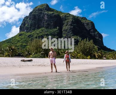 Zwei Reisende schlendern entlang eines ruhigen Strandes in Mauritius und genießen den weichen Sand und das klare blaue Wasser. Le Morne, Mauritius Stockfoto