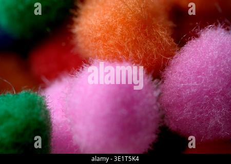 Weiche, flauschige Pompons in leuchtenden Farben laden zu Kreativität und Spaß ein. Stockfoto