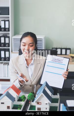 Immobilienmakler-Hausminiaturmodell zum Dokumentenverkauf und -Kauf notarieller Urkunden Stockfoto