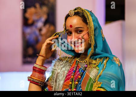 Eine junge Frau in Udaipur posiert in traditioneller Kleidung mit einer blauen Dupatta mit goldenem Besatz, schweren Armreifen und einem dekorativen Bindi auf der Stirn. Stockfoto