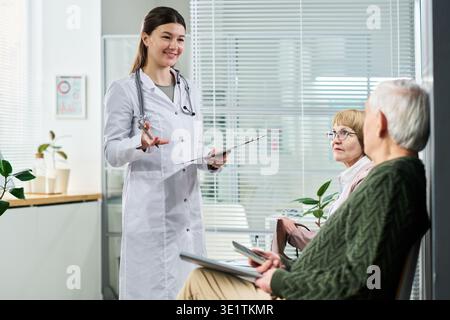 Junge Ärztin beratendes Seniorenpaar in der Klinik Stockfoto