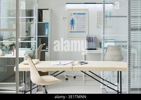 Leerer medizinischer Untersuchungsraum mit Schreibtisch und Untersuchungstisch in der Klinik Stockfoto