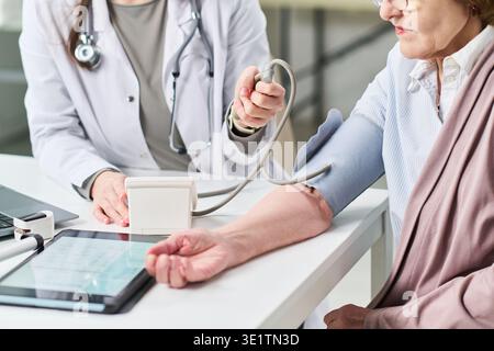 Erwachsene Frau mit ärztlicher Blutdruckkontrolle Stockfoto