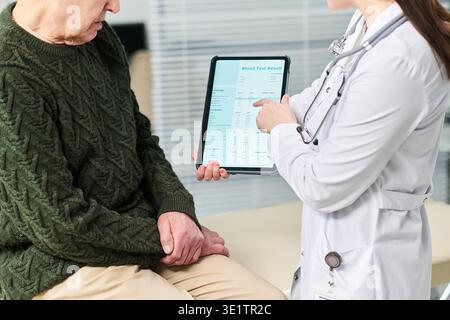 Erwachsener Mann Beratender Weiblicher Arzt, Der Die Ergebnisse Von Bluttests Überprüft Stockfoto