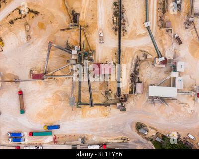 Luftaufnahme der Industrielandschaft, wo Erdtöne auf die Geometrie von Maschinen und Fahrzeugen treffen, Arsoli, Latium, Italien. Stockfoto