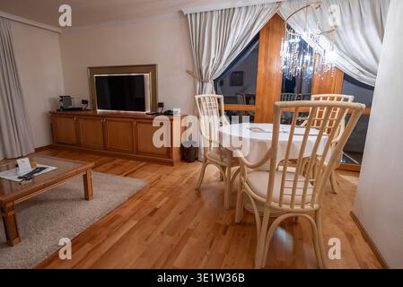 Warmer Ess- und Wohnbereich der Hotelsuite mit alpinen Holzakzenten Stockfoto