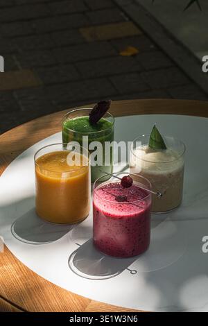Verschiedene bunte Smoothies in Glasbechern Stockfoto