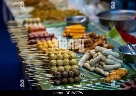 Bangkok Thailand 15. Januar 2026. Verschiedene gegrillte Fleisch- und Fischkugelspieße auf dem Regal am Street Food Stand. Stockfoto