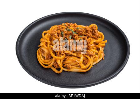 Herzhafte italienische Bolognese-Pasta mit herzhafter Fleischsoße auf dunklem Teller vor hellem neutralen Hintergrund, mit Blick von oben Stockfoto
