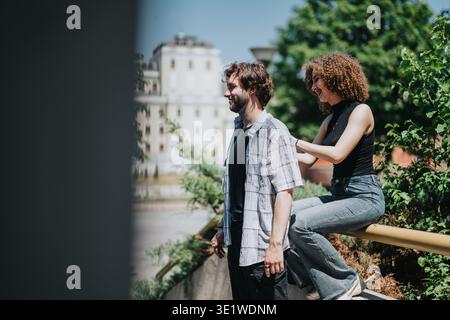 Freunde hängen an einem sonnigen Tag ab, lockere Unterhaltung am Geländer und Grün Stockfoto