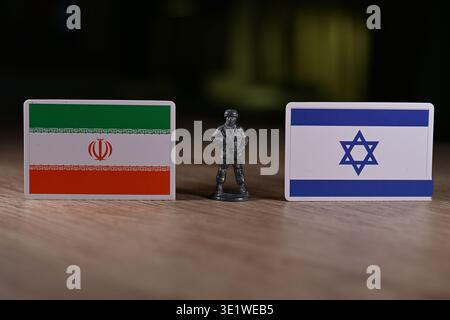 Ein Zinnsoldat auf dem Hintergrund der Flaggen von Iran und Israel. Stockfoto