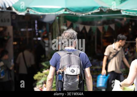 Rucksacktouristen erkunden den Markt im Freien, Rückansicht. Stockfoto