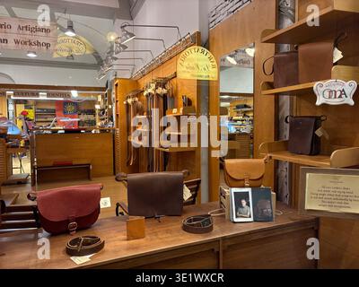Innenraum der Handwerkstatt mit handgefertigten Taschen und Gürteln auf dem Ausstellungstisch. Florenz, Italien. Stockfoto