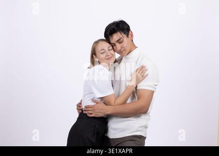 Junges romantisches Paar, das sich umarmt und anlächelt Stockfoto