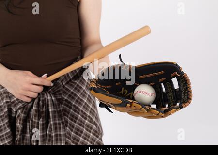 Nahaufnahme einer Frau, die Baseballschläger und Handschuh mit Ball hält Stockfoto
